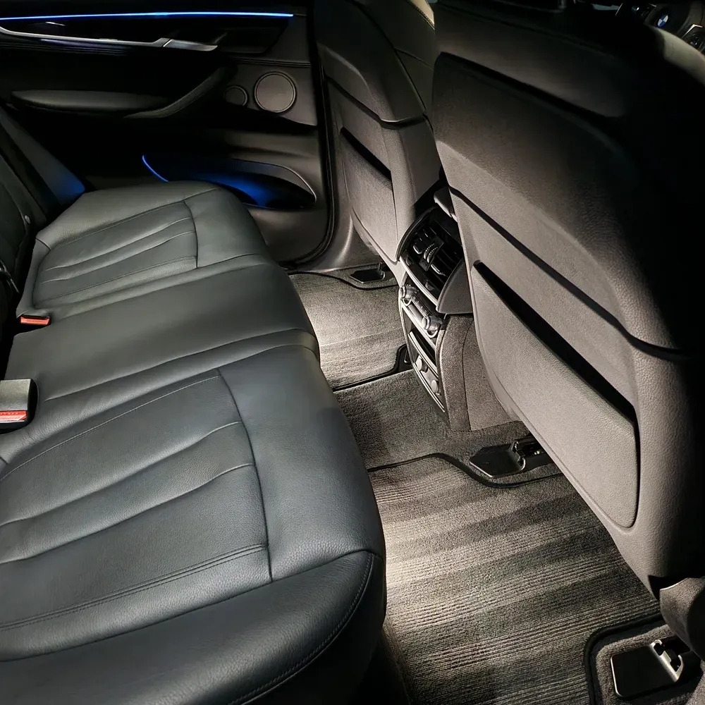 Black leather rear seats and clean carpets of a BMW SUV after a full interior detail in Reno, NV