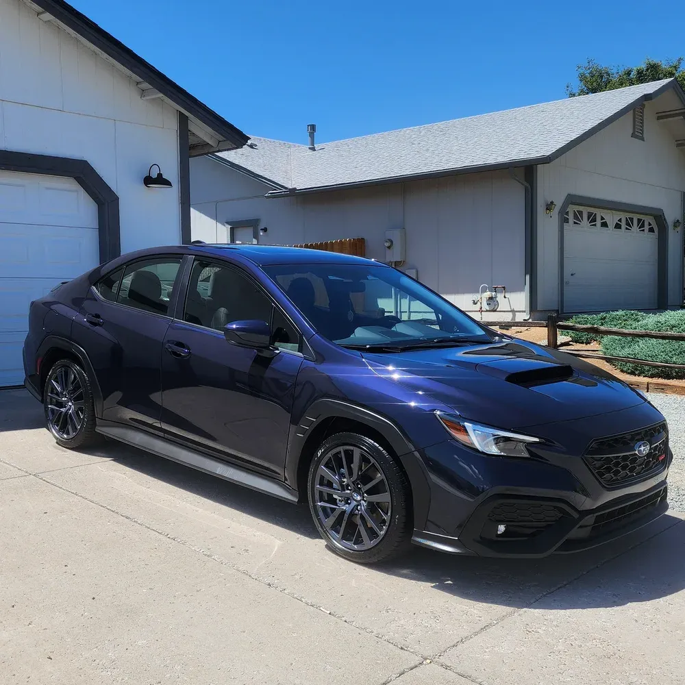Dark blue Subaru WRX detailed in a residential Reno driveway, paint reflecting the sky
